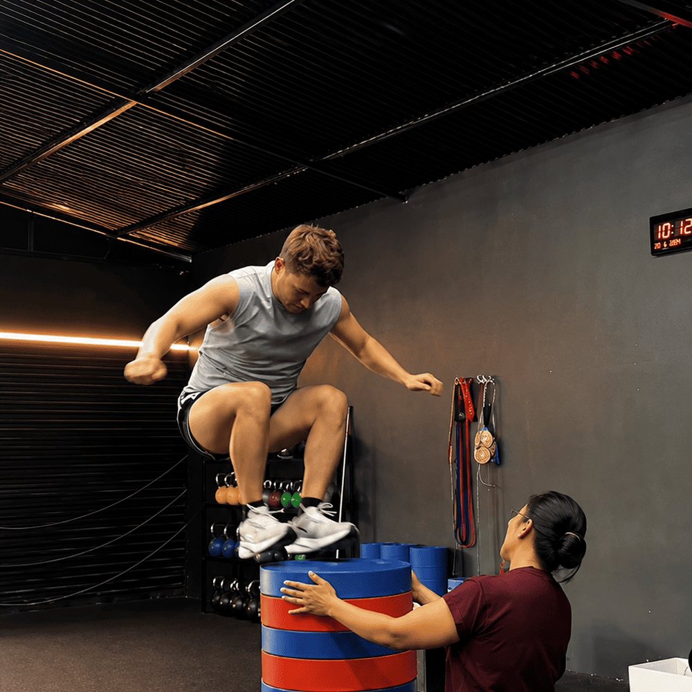 Box jump training with a coach spotting
